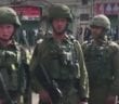 Confronting “brave” Israeli soldiers pointing guns a children